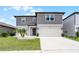 Contemporary two-story home featuring a gray color scheme, well-manicured lawn, and a spacious two-car garage at 5663 Keaton Springs Dr, Lakeland, FL 33811
