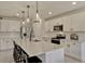 Spacious kitchen with white cabinetry, stainless steel appliances, a center island with seating, and modern pendant lights at 5663 Keaton Springs Dr, Lakeland, FL 33811