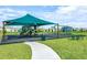 Well-maintained community playground with green canopy, swings, slide, and picnic tables at 5663 Keaton Springs Dr, Lakeland, FL 33811