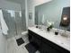 Modern bathroom featuring double sinks, quartz countertop, marble tile floor, and a glass-enclosed shower at 695 Whistling Straits Blvd, Davenport, FL 33896