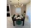 Bright dining room showcasing a modern chandelier and table set for a dinner, exuding comfort at 695 Whistling Straits Blvd, Davenport, FL 33896