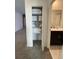 Hallway featuring an open closet, leading to a bathroom with a dark vanity and light countertops at 695 Whistling Straits Blvd, Davenport, FL 33896