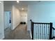 Upstairs hallway featuring neutral carpeting and black iron railings at 695 Whistling Straits Blvd, Davenport, FL 33896