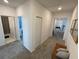 Hallway with neutral carpet, offering views of nearby rooms and a comfortable sitting bench at 695 Whistling Straits Blvd, Davenport, FL 33896