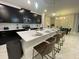 Well-lit kitchen featuring black cabinets, a large island with seating, and modern pendant lights at 695 Whistling Straits Blvd, Davenport, FL 33896