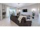 Stylish living room with a modern sofa, marble floors, and an adjacent screened patio at 695 Whistling Straits Blvd, Davenport, FL 33896