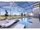 Enclosed pool and jacuzzi area with lounge chairs and a view of the surrounding landscape at 695 Whistling Straits Blvd, Davenport, FL 33896