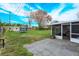 Spacious backyard featuring a grassy lawn, screen enclosure, and trampoline on a sunny day at 711 Montana Ave, St Cloud, FL 34769