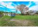 Expansive backyard with green grass and a blue trampoline under a bright sky at 711 Montana Ave, St Cloud, FL 34769