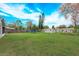 Grassy backyard with a trampoline, shed, and fenced perimeter under a bright sky at 711 Montana Ave, St Cloud, FL 34769