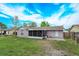 Exterior of a house with a large backyard, featuring a screened patio and green lawn at 711 Montana Ave, St Cloud, FL 34769