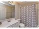 Well-lit bathroom with a white vanity, shower with patterned curtain, and a skylight at 711 Montana Ave, St Cloud, FL 34769