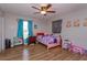 Bright bedroom featuring laminate floors, ceiling fan, and a cheerful decor with colorful furnishings at 711 Montana Ave, St Cloud, FL 34769