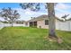 Backyard featuring a well-maintained lawn, white fence, and large tree at 719 Postrio Way, Ocoee, FL 34761