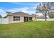 Backyard featuring a well-maintained lawn, white fence, and part of house at 719 Postrio Way, Ocoee, FL 34761