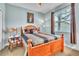 Well-lit bedroom with wood-framed bed, ceiling fan, and carpeted floors at 719 Postrio Way, Ocoee, FL 34761