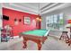 Billiard room with green felt pool table, pool cue rack, and a window with natural light at 719 Postrio Way, Ocoee, FL 34761