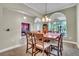 Formal dining room with arched windows and doorways, chandelier, and adjacent view of the billiards room at 719 Postrio Way, Ocoee, FL 34761