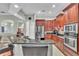 Modern kitchen with granite counters, stainless steel appliances, and cherry wood cabinets at 719 Postrio Way, Ocoee, FL 34761