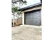 Exterior of the garage, featuring a new gray door, black trim, and landscaping at 722 Eagle Ave, Longwood, FL 32750