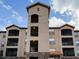 Stunning exterior view of a multi-story building with balconies, under a beautiful blue sky with scattered clouds at 8010 Tuscany Way # 5206, Davenport, FL 33896