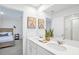 Bright bathroom with double vanity, quartz countertop, wall art, and glass shower enclosure at 8903 Caroline Bay Ct, Kissimmee, FL 34747