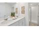 Bright bathroom with double vanity, quartz countertop, framed wall art, and glass shower enclosure at 8903 Caroline Bay Ct, Kissimmee, FL 34747