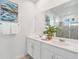 Bathroom featuring double sinks, a large mirror, and a glass-enclosed shower at 8903 Caroline Bay Ct, Kissimmee, FL 34747