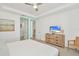 Bright bedroom featuring neutral walls, ceiling fan, and wooden dresser with television at 8903 Caroline Bay Ct, Kissimmee, FL 34747