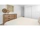 Neutral bedroom with a dresser and closet near a comfortably made bed at 8903 Caroline Bay Ct, Kissimmee, FL 34747