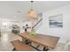 Bright dining area with rustic table set, pendant lighting, artwork, and a view of modern kitchen at 8903 Caroline Bay Ct, Kissimmee, FL 34747