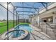 View of the pool, spa, covered lanai and home from within the screened enclosure at 8903 Caroline Bay Ct, Kissimmee, FL 34747