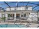 View of the rear of this two-story home featuring a screened in pool and patio at 8903 Caroline Bay Ct, Kissimmee, FL 34747