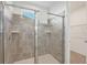 Tiled shower with glass doors, built-in niche, and small window for natural light at 8903 Caroline Bay Ct, Kissimmee, FL 34747