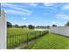 A peaceful backyard features a lake view, complete with a black metal fence and well-manicured lawn at 905 Bella Vista Way, Orlando, FL 32825