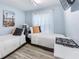 Stylized twin bedroom with beach decor and ample natural light from the sheer curtained window at 905 Bella Vista Way, Orlando, FL 32825