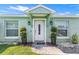 Charming home featuring a white front door with decorative plants and a well-manicured lawn at 905 Bella Vista Way, Orlando, FL 32825