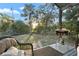 View of the private fenced backyard with mature trees, outdoor grill, and cozy patio seating at 910 Florida Blvd, Altamonte Springs, FL 32701