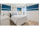 Comfortable bedroom with a queen-sized bed, nautical accents, and plenty of natural light at 915 Princess Sabal Pt, Haines City, FL 33844