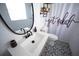 Updated bathroom features a white vanity, black faucet and hardware and decorative tiling at 1002 Royalton Rd, Orlando, FL 32825