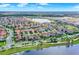 A panoramic view shows lakefront houses in a community with a picturesque waterfront promenade with palm trees at 10249 Beechwood Ln, Orlando, FL 32832