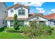 Two-story home featuring a red tile roof, well-maintained lawn, and mature landscaping at 10249 Beechwood Ln, Orlando, FL 32832