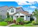 Inviting two-story home featuring a red tile roof, manicured lawn, and lush, colorful landscaping at 10249 Beechwood Ln, Orlando, FL 32832