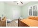 Bright bedroom features wood-look floors, a ceiling fan, and a large window for natural light at 10361 Mallard Landings Way, Orlando, FL 32832