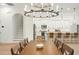 Bright dining area showcasing an elegant chandelier, staircase, and modern kitchen with an island and barstool seating at 10361 Mallard Landings Way, Orlando, FL 32832