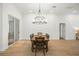 Spacious dining area with wood-look tile flooring, a rustic table, modern lighting, and a sliding glass door at 10361 Mallard Landings Way, Orlando, FL 32832