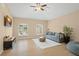 Cozy living room with hardwood floors, ceiling fan, and large windows at 10361 Mallard Landings Way, Orlando, FL 32832