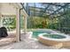 Inviting screened-in pool area with a hot tub, patio, and lush landscaping at 10361 Mallard Landings Way, Orlando, FL 32832