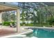 Relaxing screened-in pool area featuring comfortable lounge chairs with serene lake views at 10361 Mallard Landings Way, Orlando, FL 32832