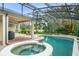 Beautiful screened-in pool and spa with a tranquil view of the lake at 10361 Mallard Landings Way, Orlando, FL 32832